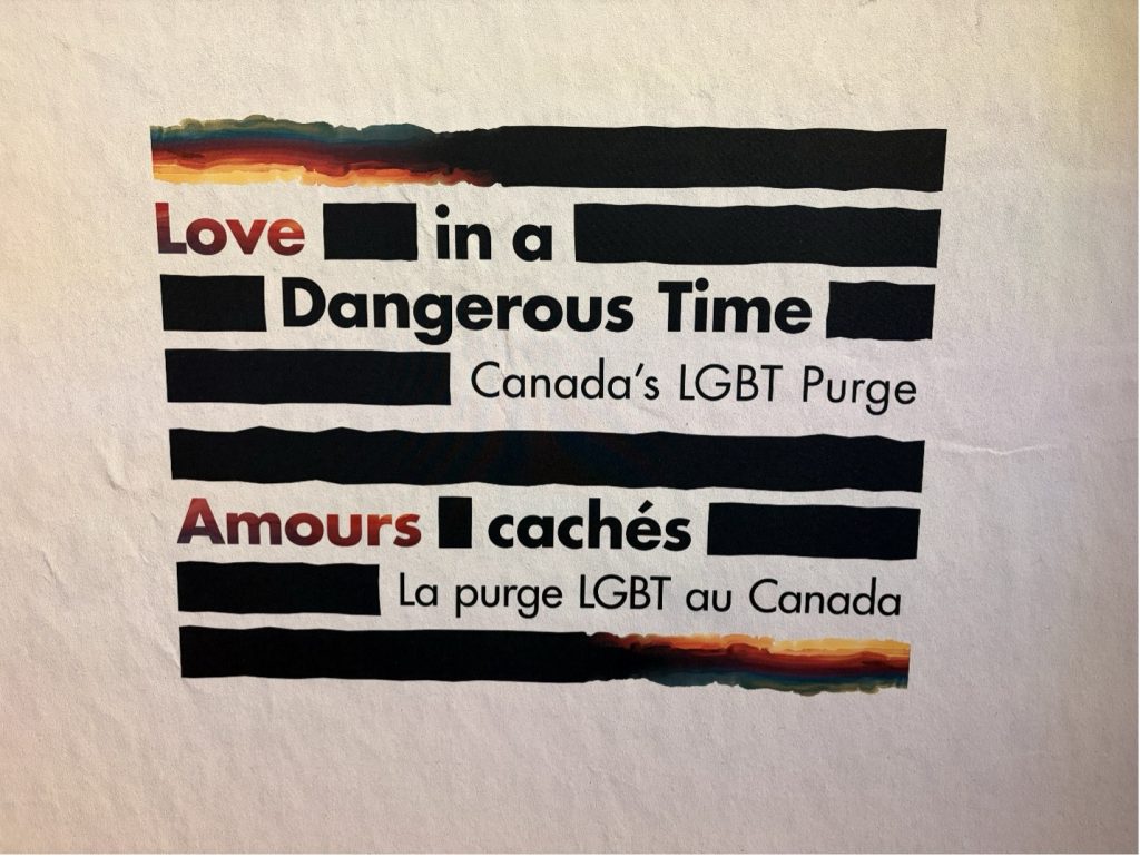 Sign for a Canadian Human Rights Museum exhibit that reads "Love in a Dangerous Time: Canada's LGBT Purge" En Français: "Amours cachés: La purge LGBT au Canada"